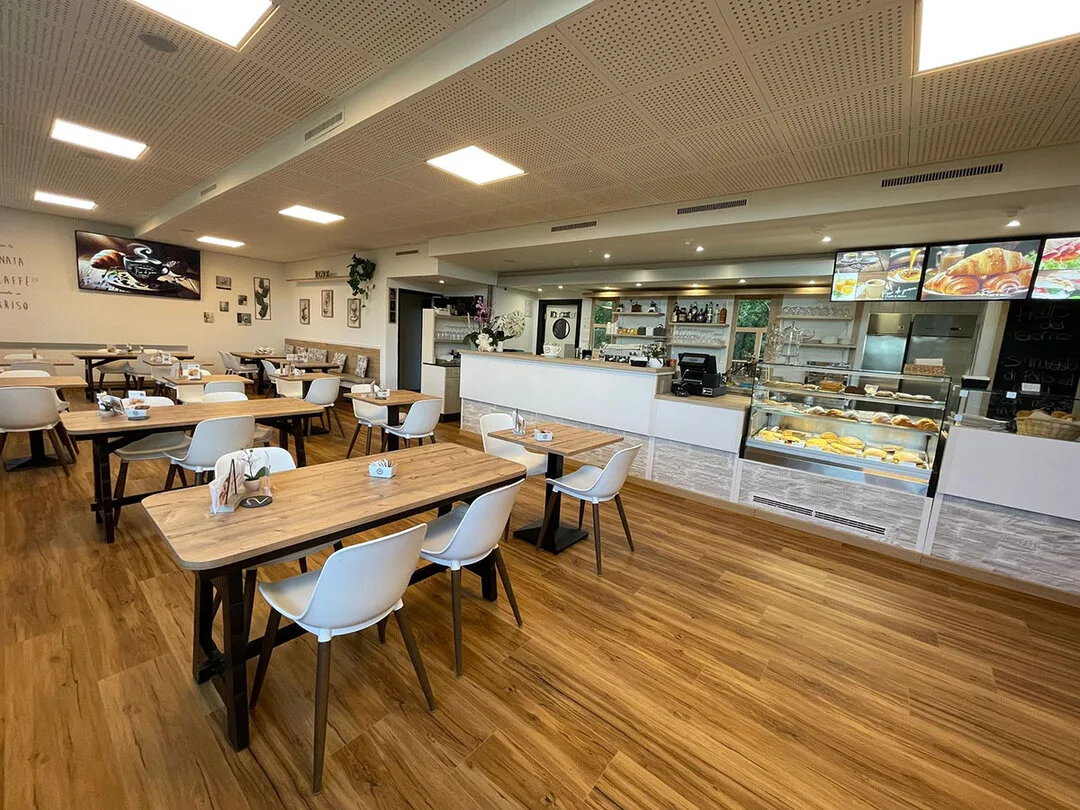 La sala di Fior di pane con i tavoli in legno e le sedie bianche, apparecchiata per il pranzo